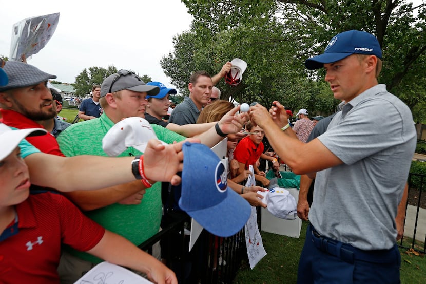 Jordan Spieth signs autographs for fans after he finishes the second round with 5-over par...