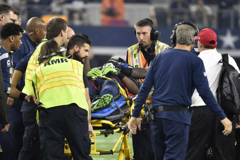 Medical staff prepare to cart Ricardo Lockette off the field as head coach Pete Carroll,...