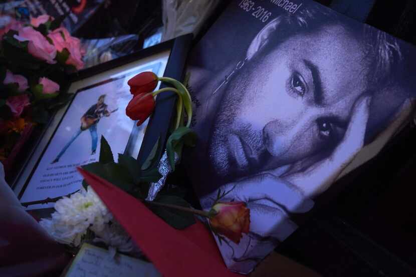 A message bearing a portrait of late British singer George Michael is seen amid flowers,...