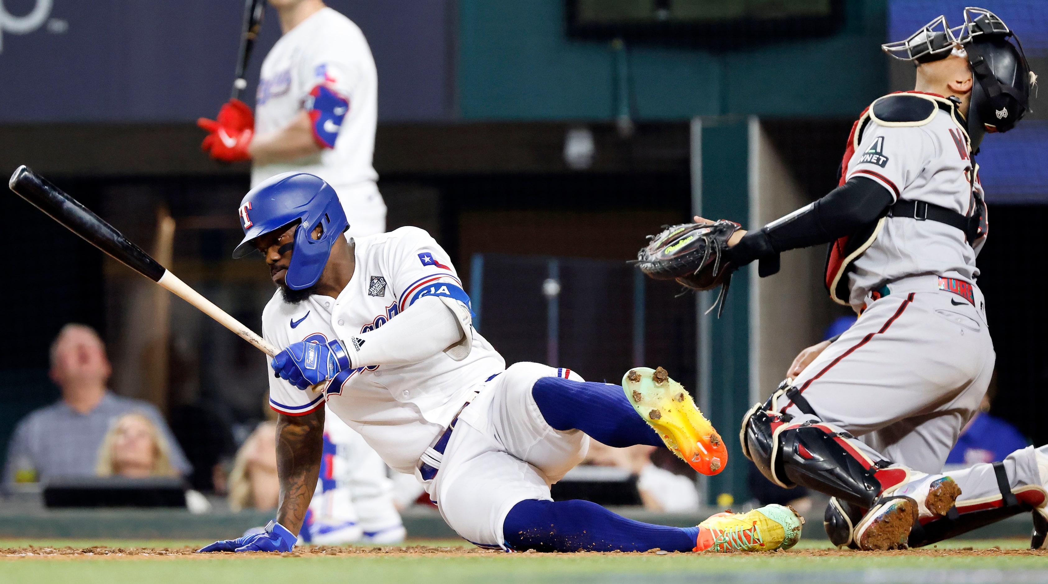 Texas Rangers' Adolis Garcia loses his footing on a foul ball during the seventh inning in...