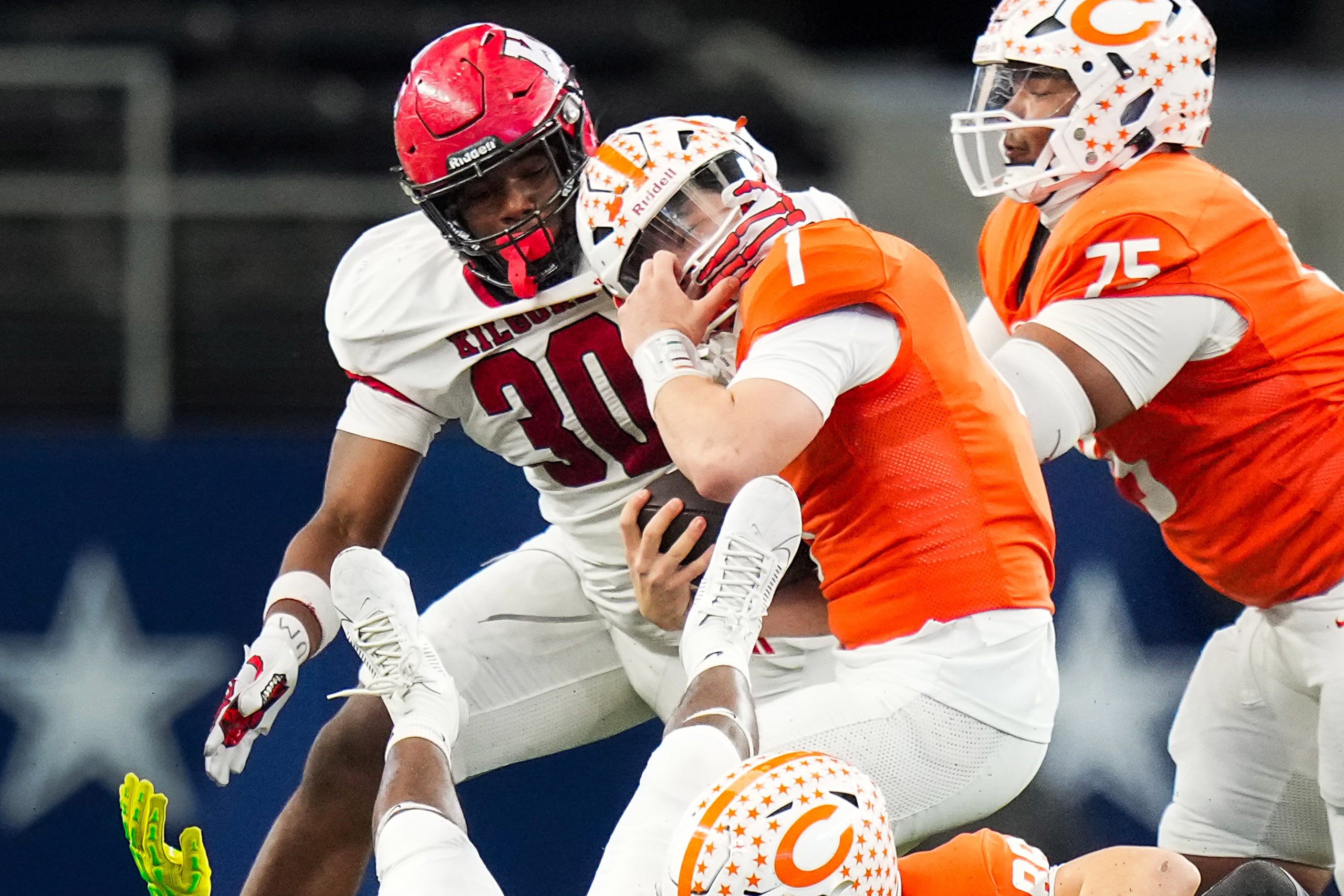 Kilgore's Wylie Mitchell (30) grabs Celina's Bowe Bentley (1) by the face mask during the...