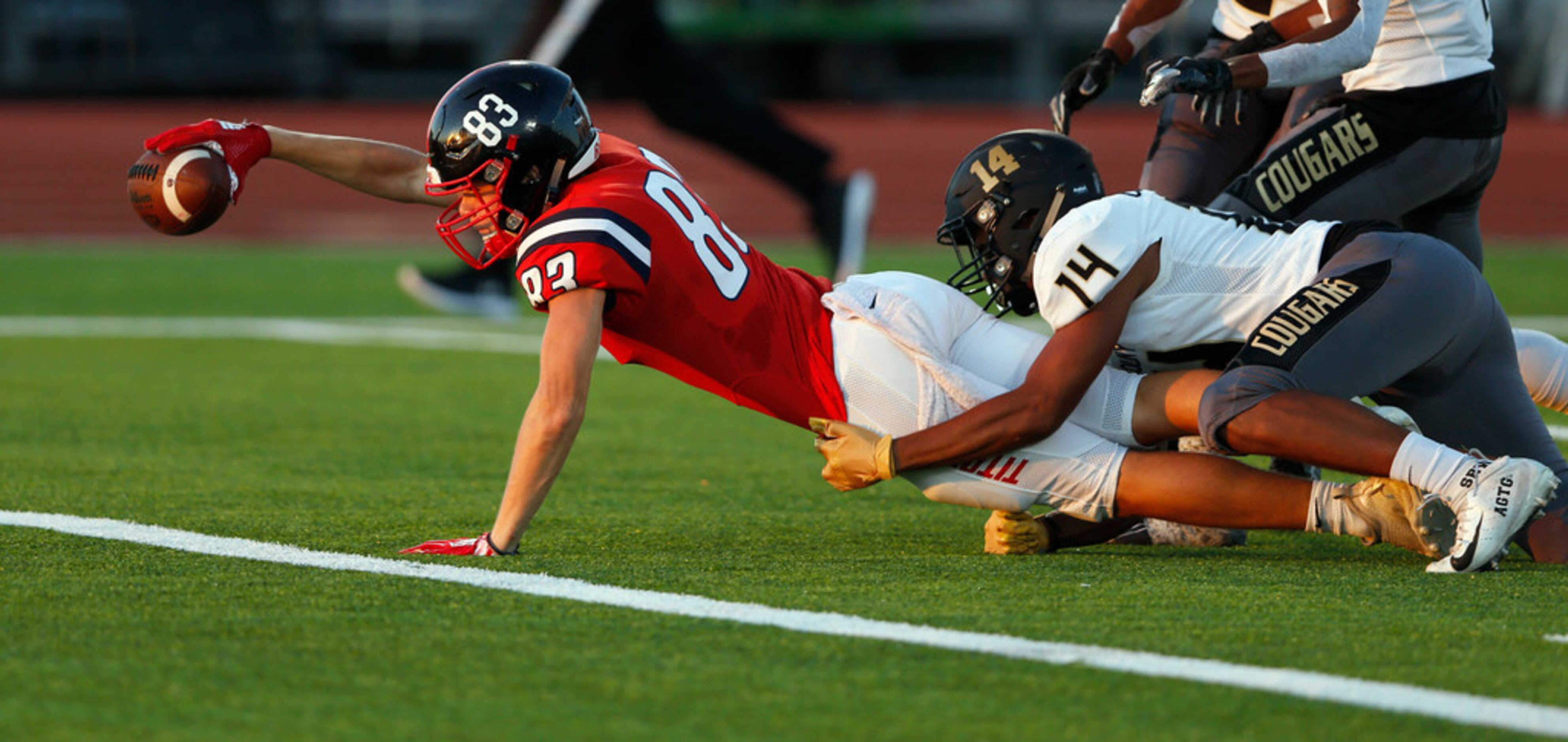 Centennial's Jacob McCoy (83) dives for the touchdown as The Colony's Stephen Wallak (14)...