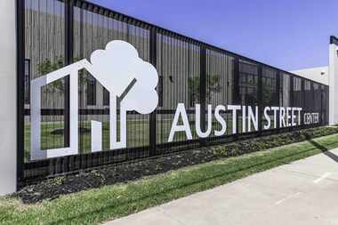 Black iron fence with the words Austin Street Center across it.