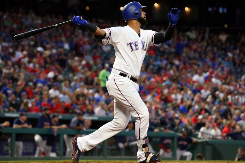 Texas Rangers' Nomar Mazara follows through on a solo home run against the Boston Red Sox...