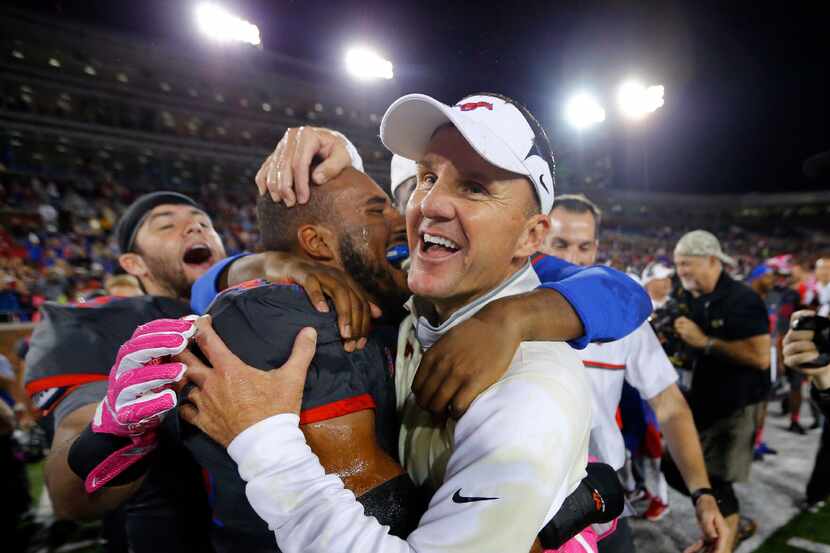 Southern Methodist Mustangs head coach Chad Morris is congratulated by linebacker Jackson...