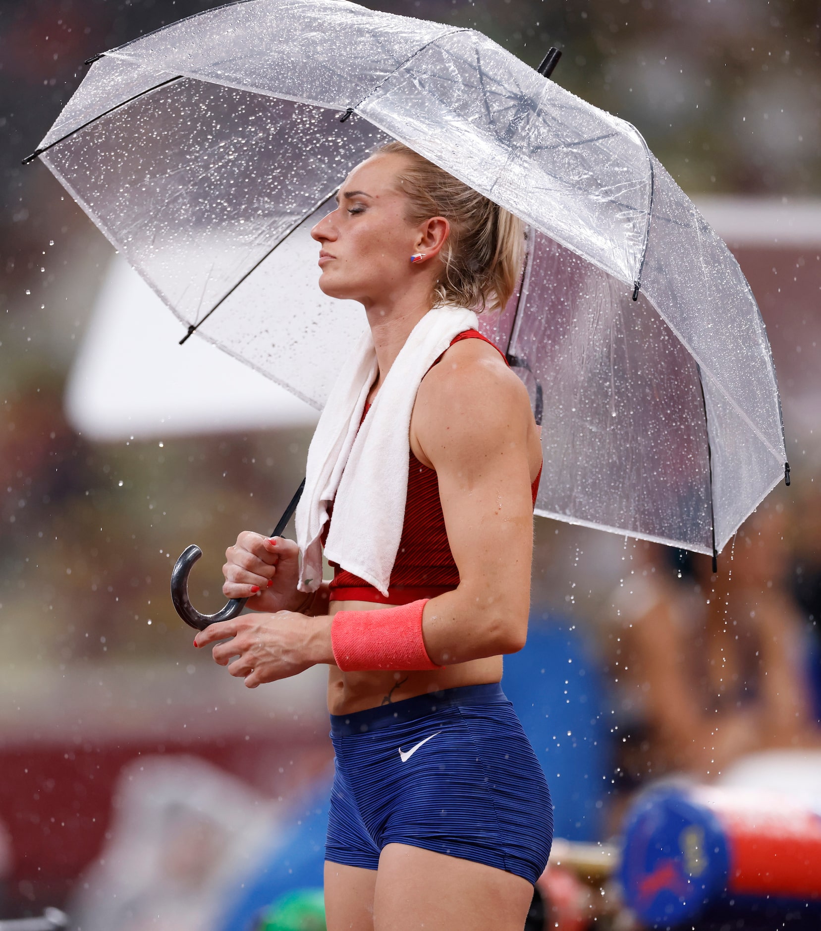 Czech Republic’s Romana Malacova keeps dry under an umbrella during a qualifying round...