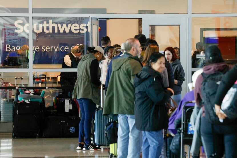 Travelers waited in line outside the Southwest Airlines baggage service office at Love Field...