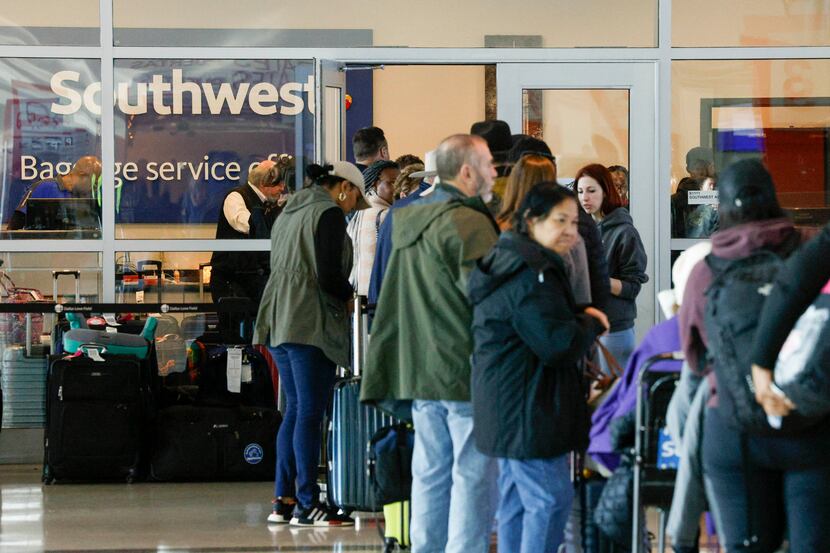 People wait in line outside a Southwest Airlines baggage service office at Dallas Love Field...