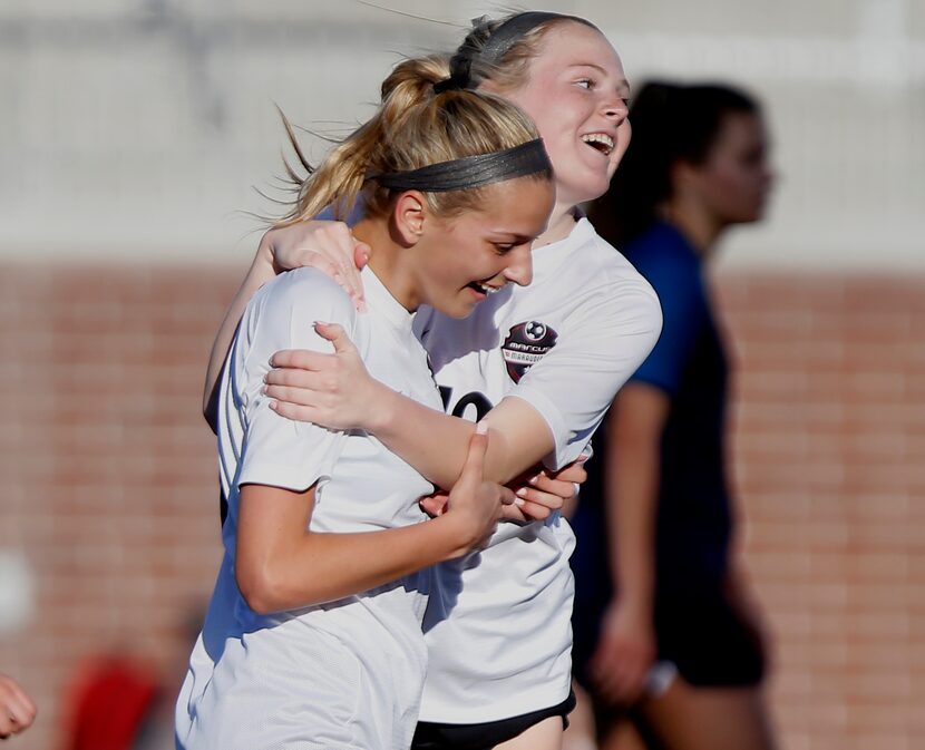 Marcus forward Caroline Castans (15) is embraced by midfielder Chloe Adams (18) after...