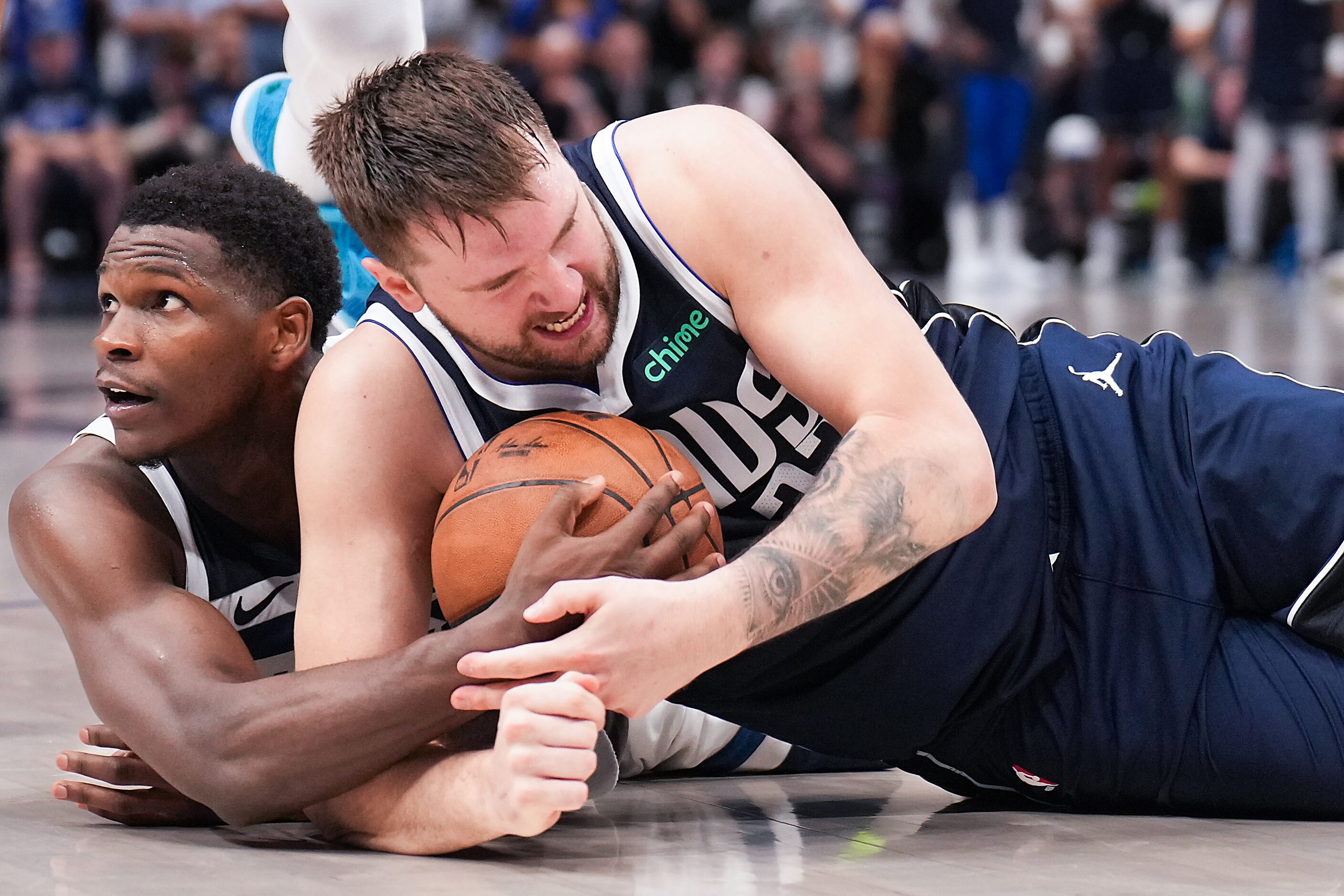 Dallas Mavericks guard Luka Doncic (77) wrestles Minnesota Timberwolves guard Anthony...