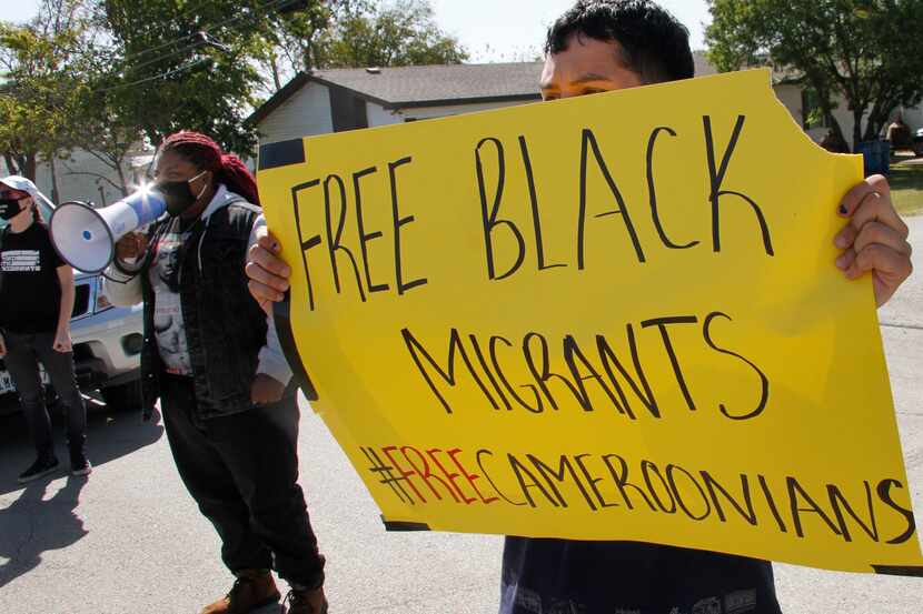 Indiana Taylor uses a megaphone to amplify her "free Black migrants" message as she along...