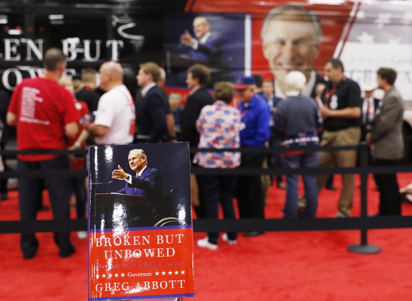 Texas Attorney Greg Abbott signs his new book, "Broken But Unbowed," during the 2016 Texas...