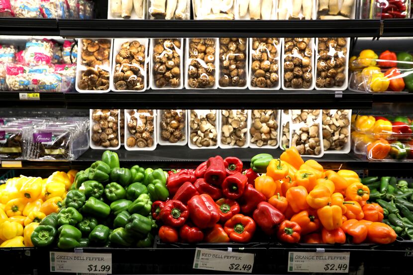 Peppers and mushrooms are on display in the produce section inside H Mart in Carrollton, Texas.