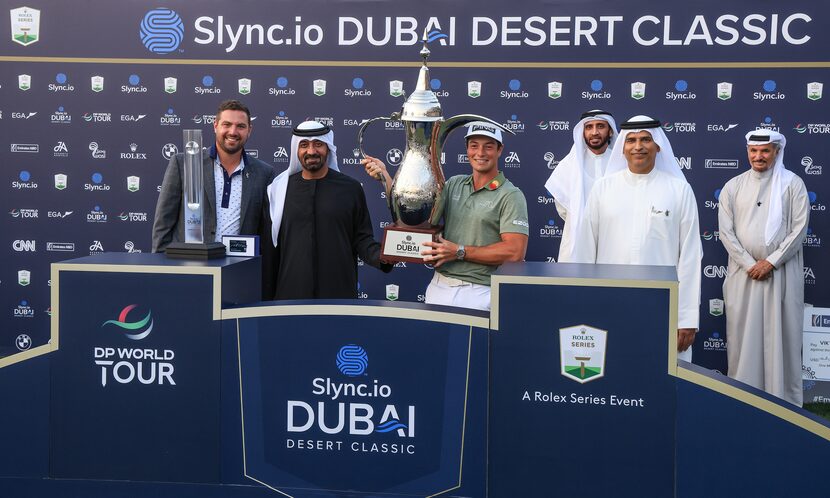 Chris Kirchner (far left) looks on as golfer Viktor Hovland of Norway is presented with the...