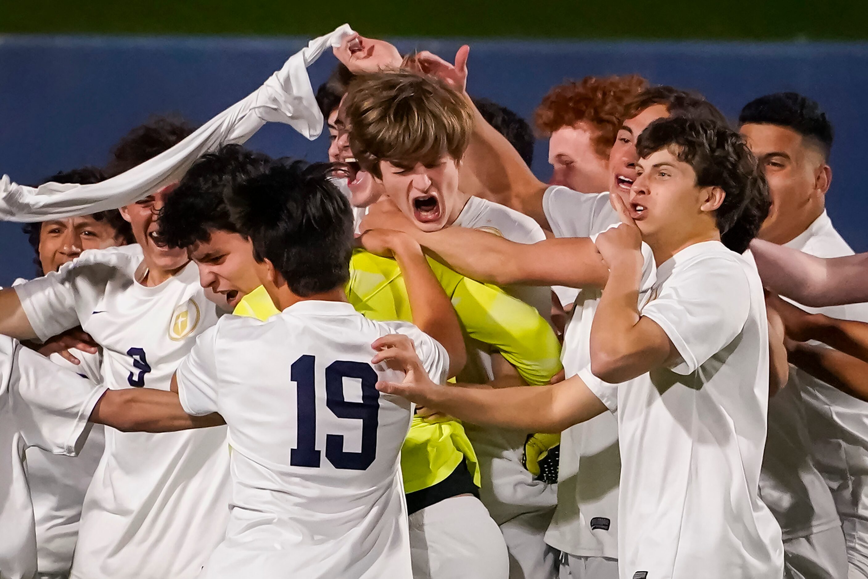 Jesuit teammates mob midfielder Sullivan Scott (center) and goalkeeper Cole Hines after...