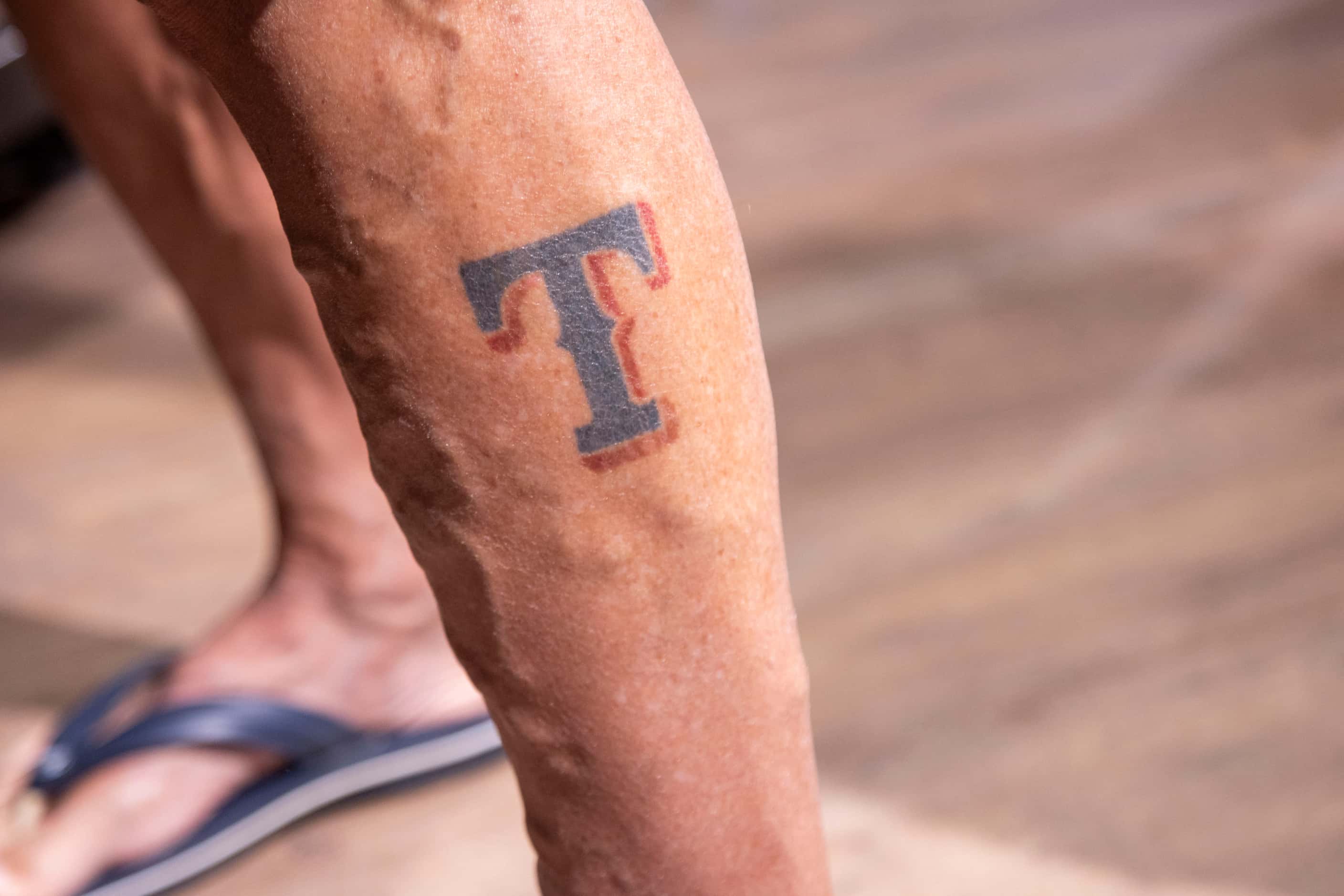 Rangers fans Randy Keadey shows his Rangers tattoo while shopping at the Grand Slam Team...