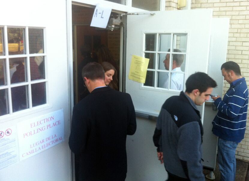 Voters stand in line as they await their turn at the polls Tuesday morning at Kent...