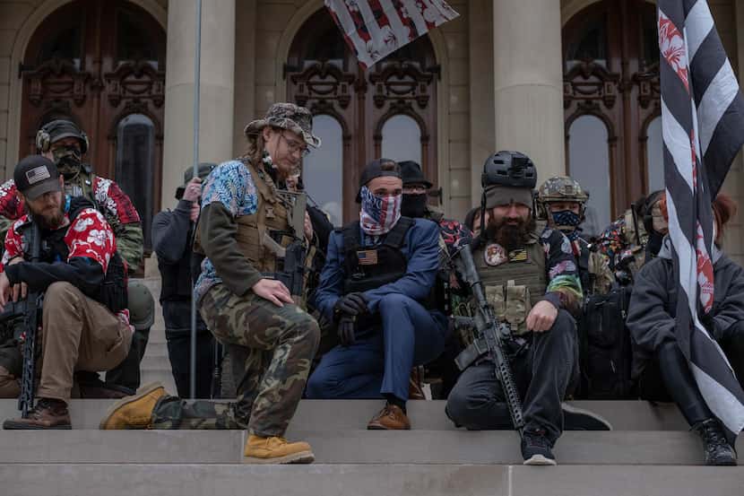 Boogaloo boys kneel on the steps of the Capitol Building on Oct. 17, 2020 during a rally in...