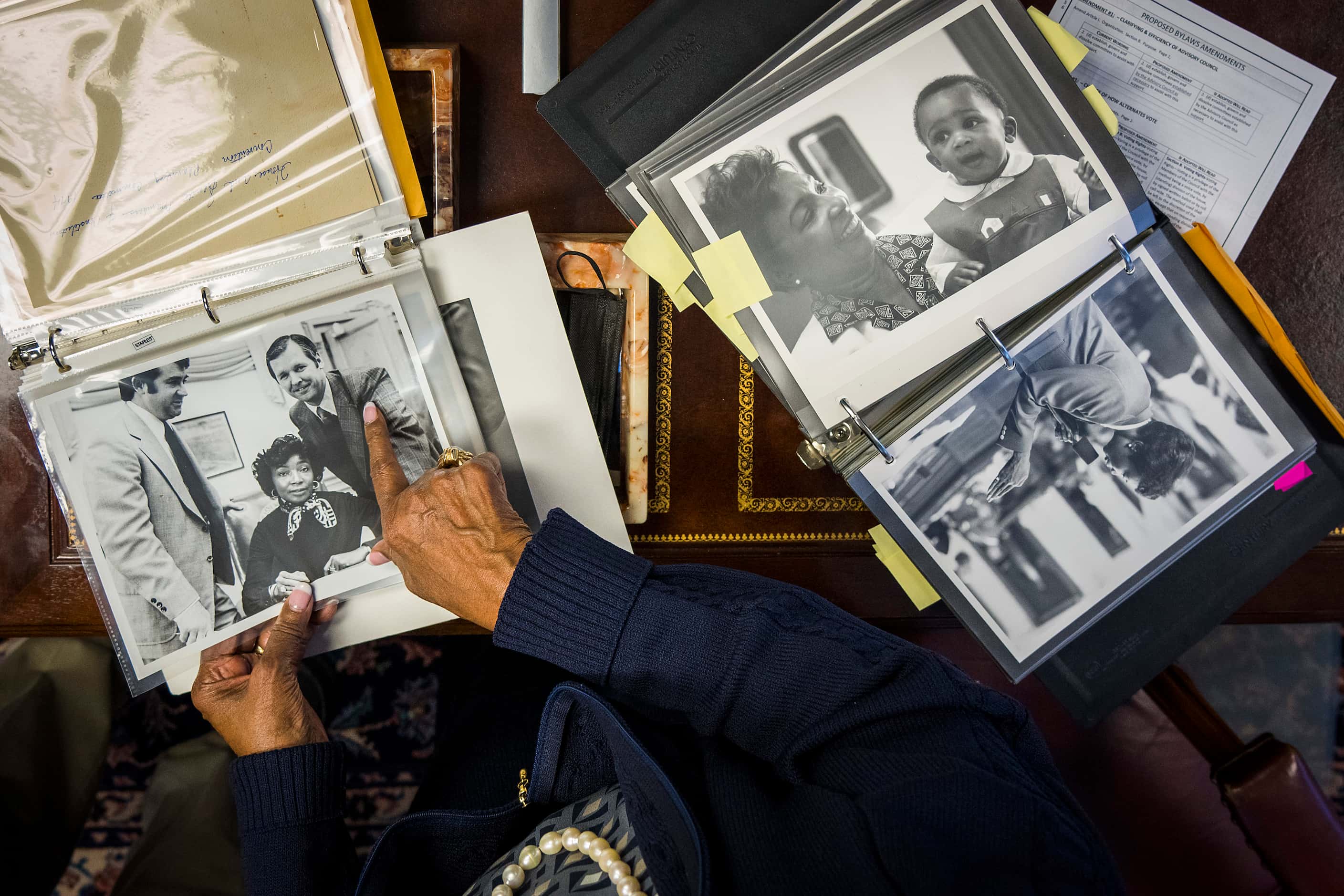 Rep. Eddie Bernice Johnson points out photos in a collection of albums while talking with...