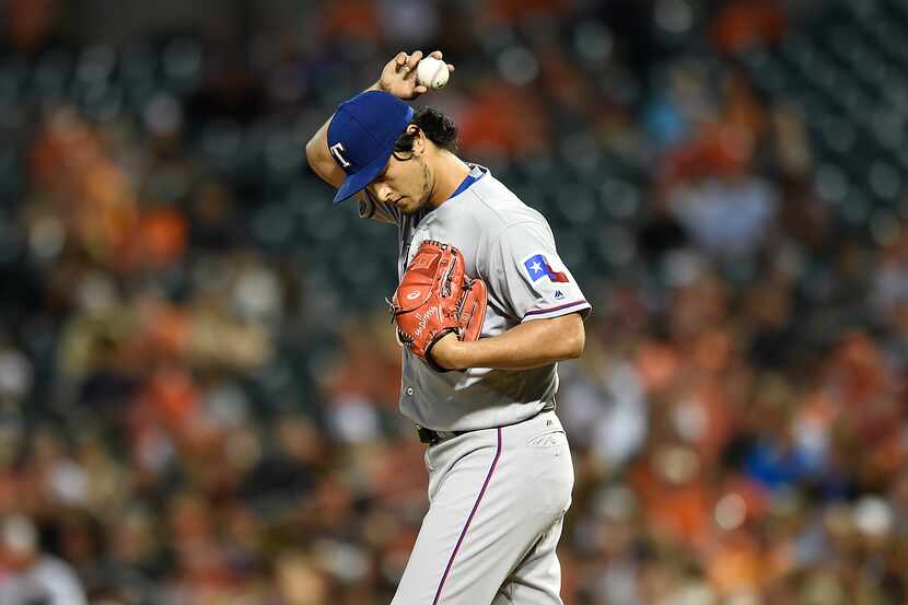 Texas Rangers pitcher Yu Darvish pauses on the mound after giving up a solo home run to the...