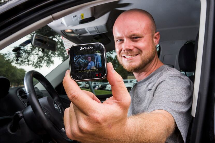 Delivery driver Derek Grippin holds a video camera that he mounts on the windshield of his...