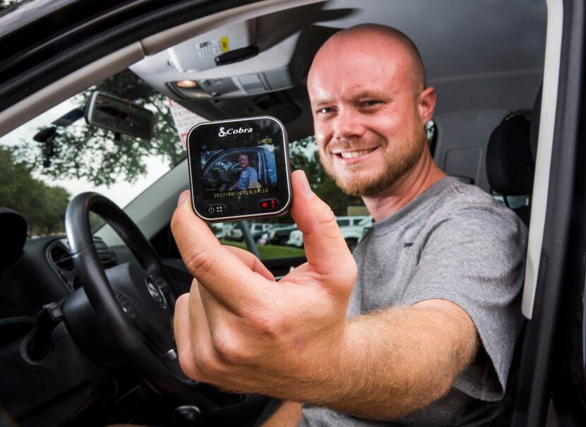 Delivery driver Derek Grippin holds a video camera that he mounts on the windshield of his...