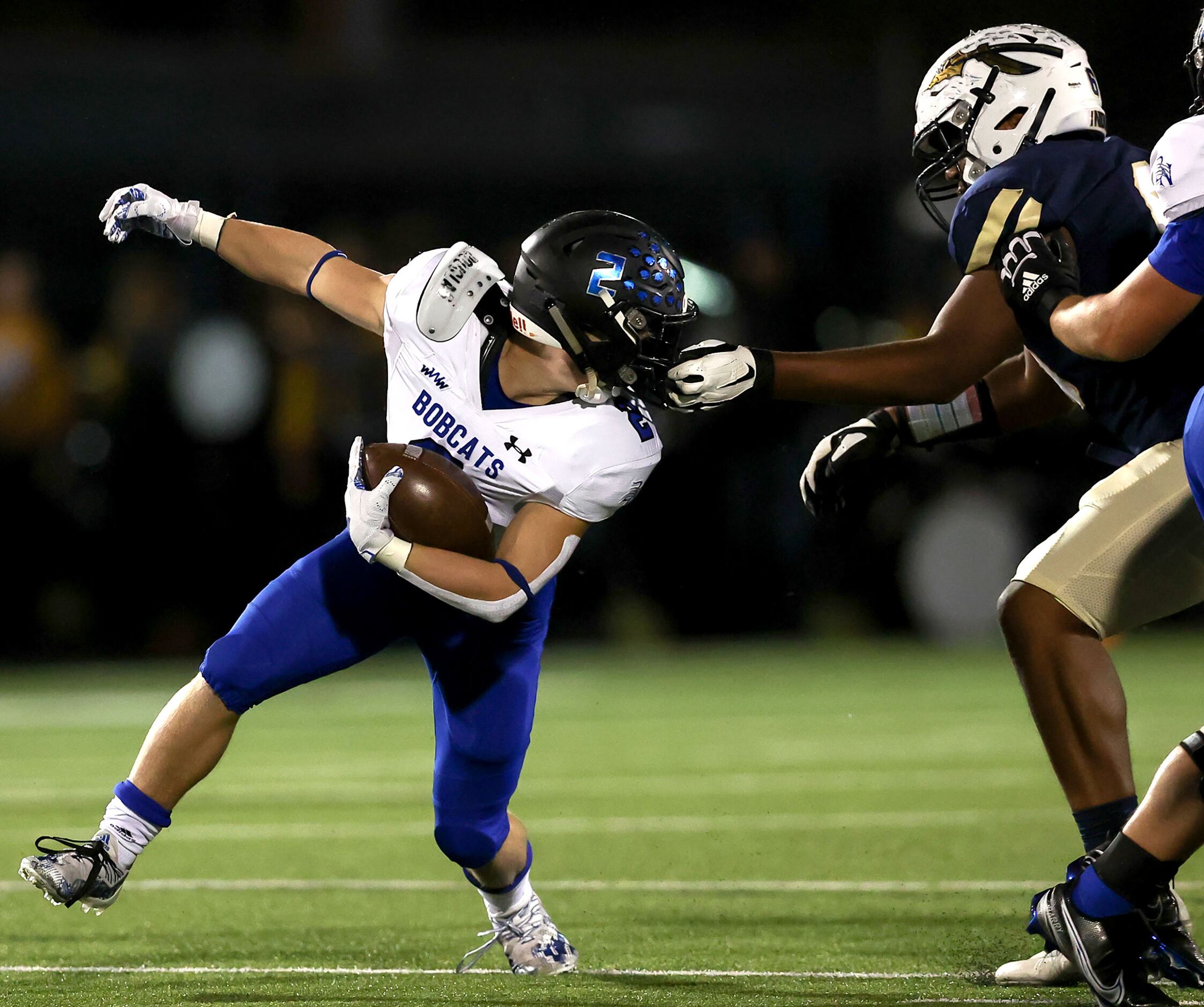 Keller defensive lineman Jon Thomas Linnear (R) gets a hold of the face mask of Byron Nelson...