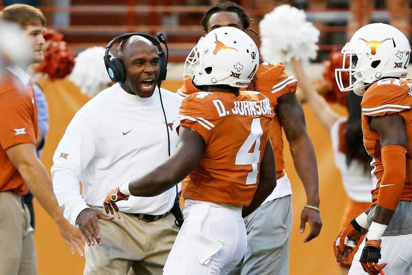 Texas head coach Charlie Strong celebrates with Daje Johnson (4) after an 85-yard punt...