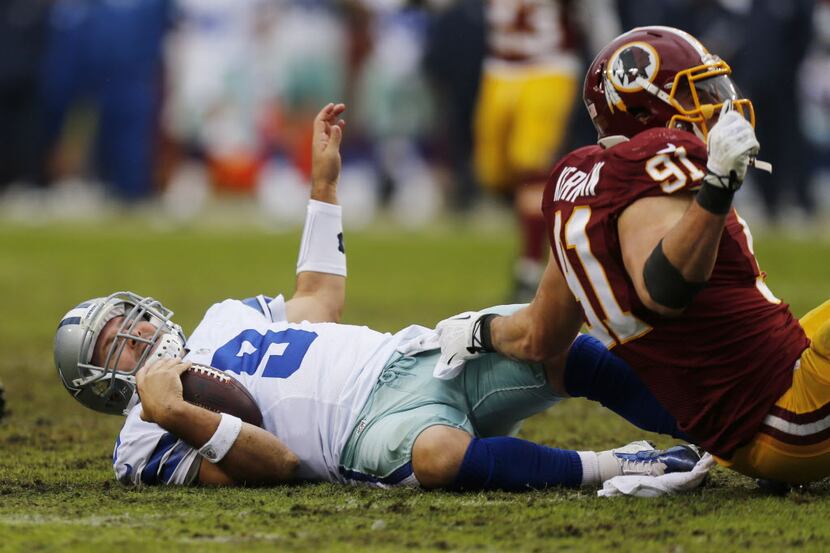 Dallas Cowboys quarterback Tony Romo (9) gets sacked by Washington Redskins outside...