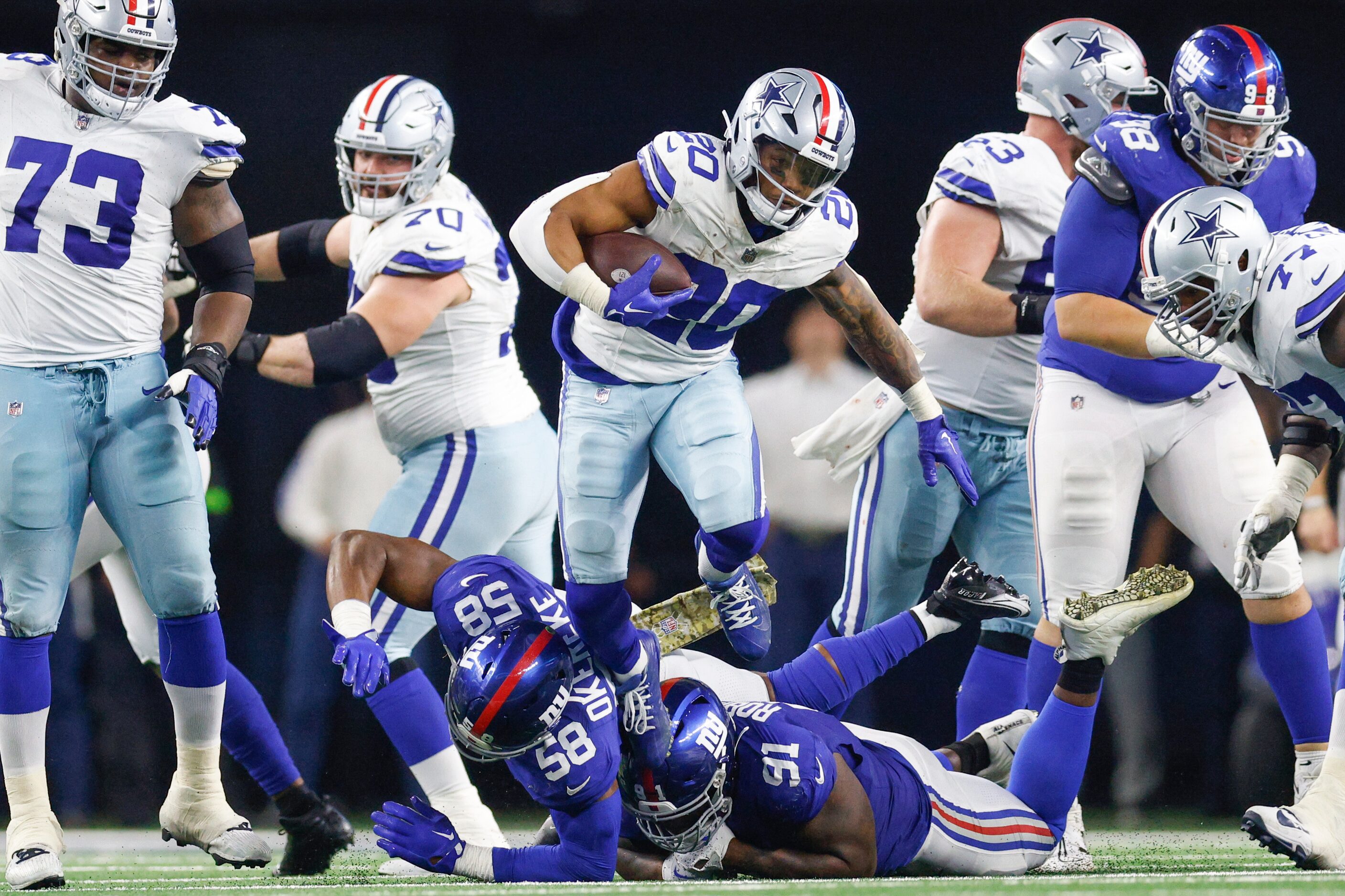 Dallas Cowboys running back Tony Pollard (20) jumps over New York Giants linebacker Bobby...