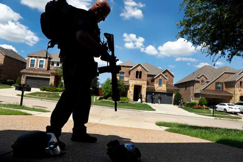 Irving SWAT team member Ryan Turner packs up his gear following a standoff with a barricaded...