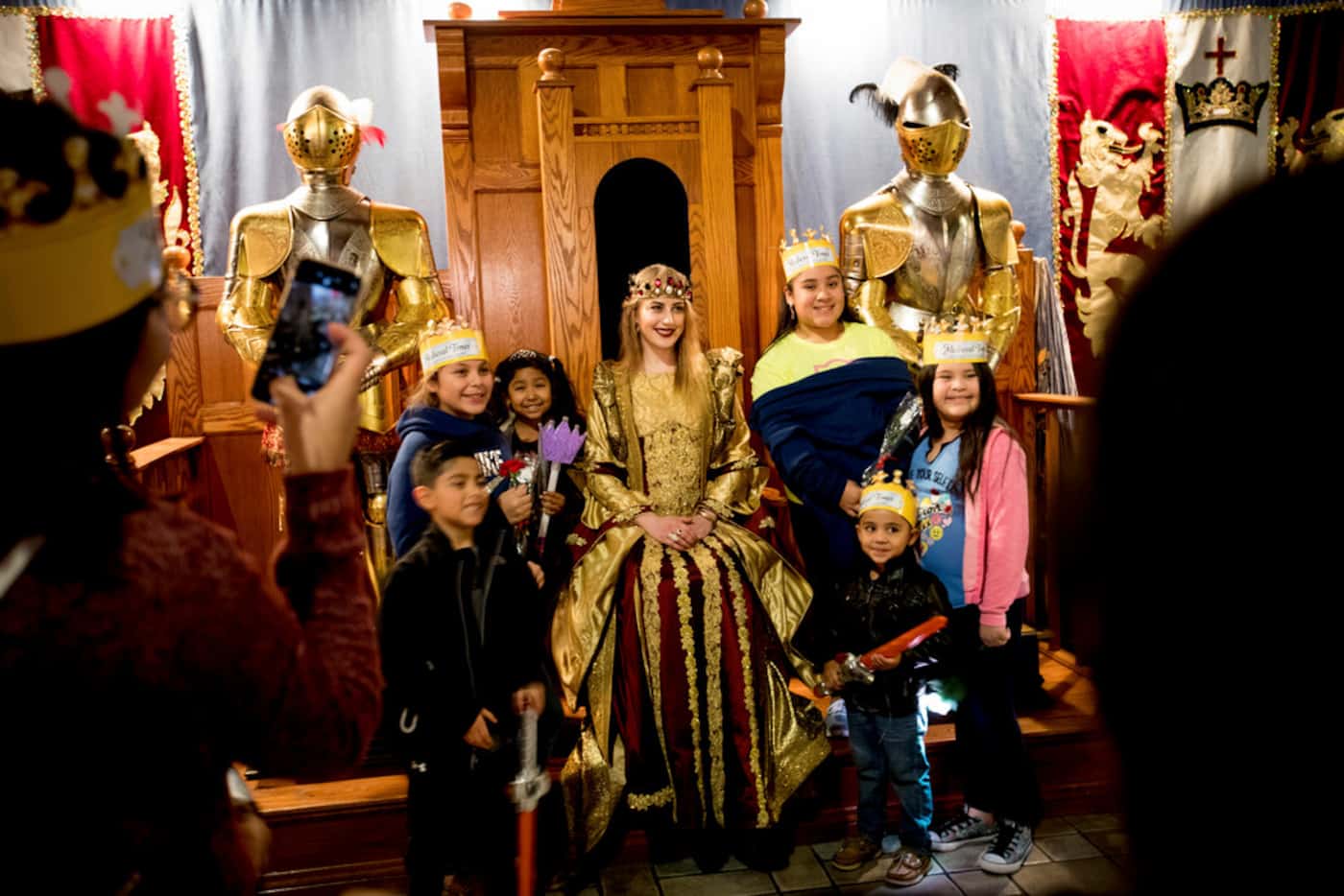 Monet Lerner, who plays the queen, poses with young guests at a Medieval Times in Dallas,...