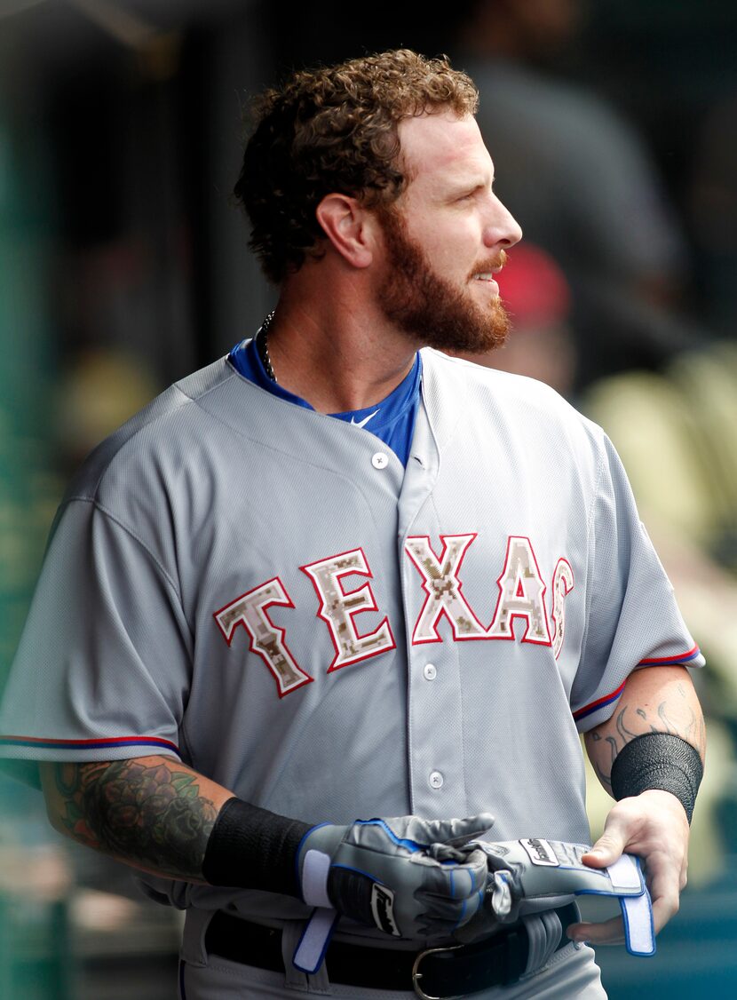 Texas Rangers Josh Hamilton takes off his gloves after striking out during the first inning...