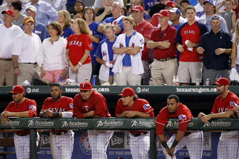 Texas Rangers players and fans watch as Rangers batter  Alex Rios (51) hits into an out to...