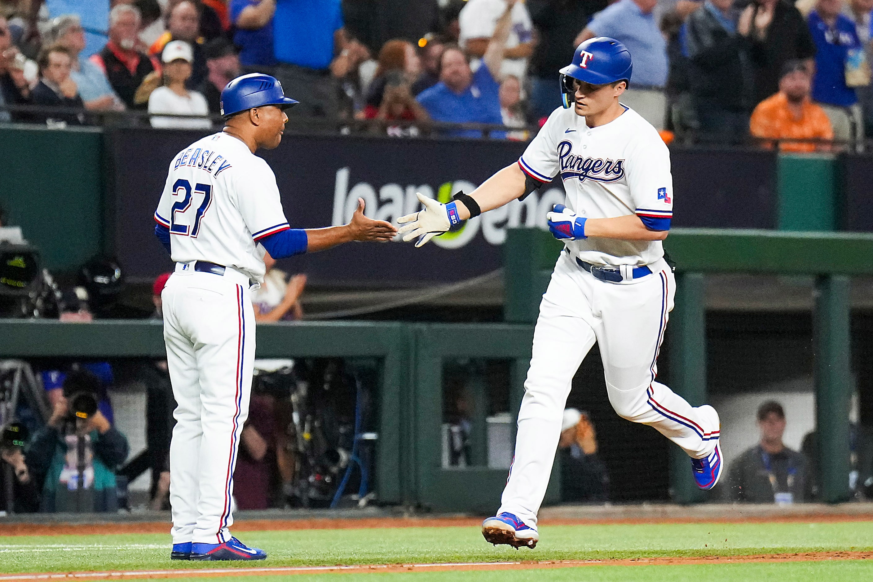 Texas Rangers shortstop Corey Seager (5) is congratulated by third base coach Tony Beasley...