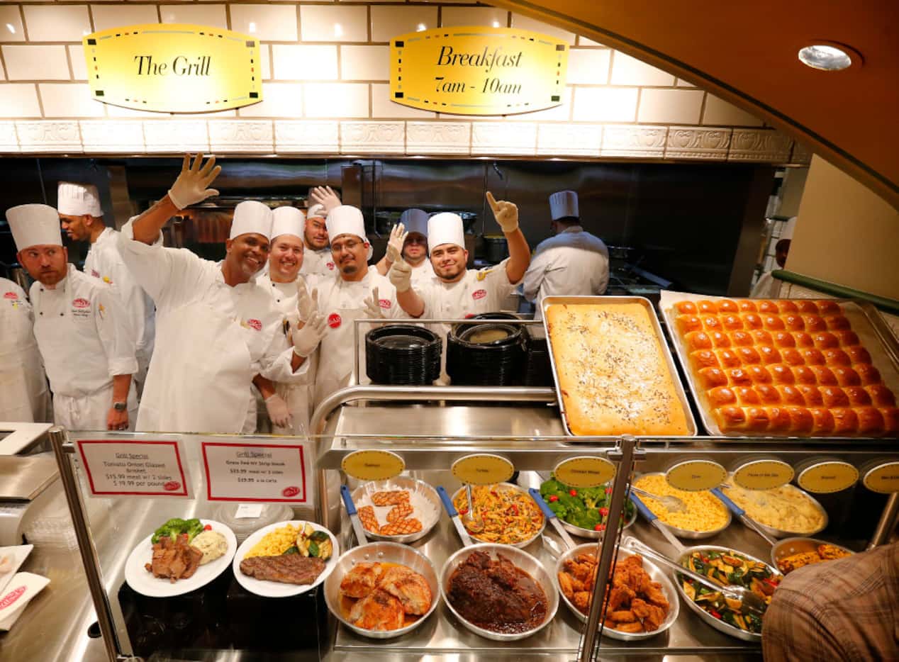 Chefs working in the kitchen gathered for a group photo during VIP night at the new Eatzi's...