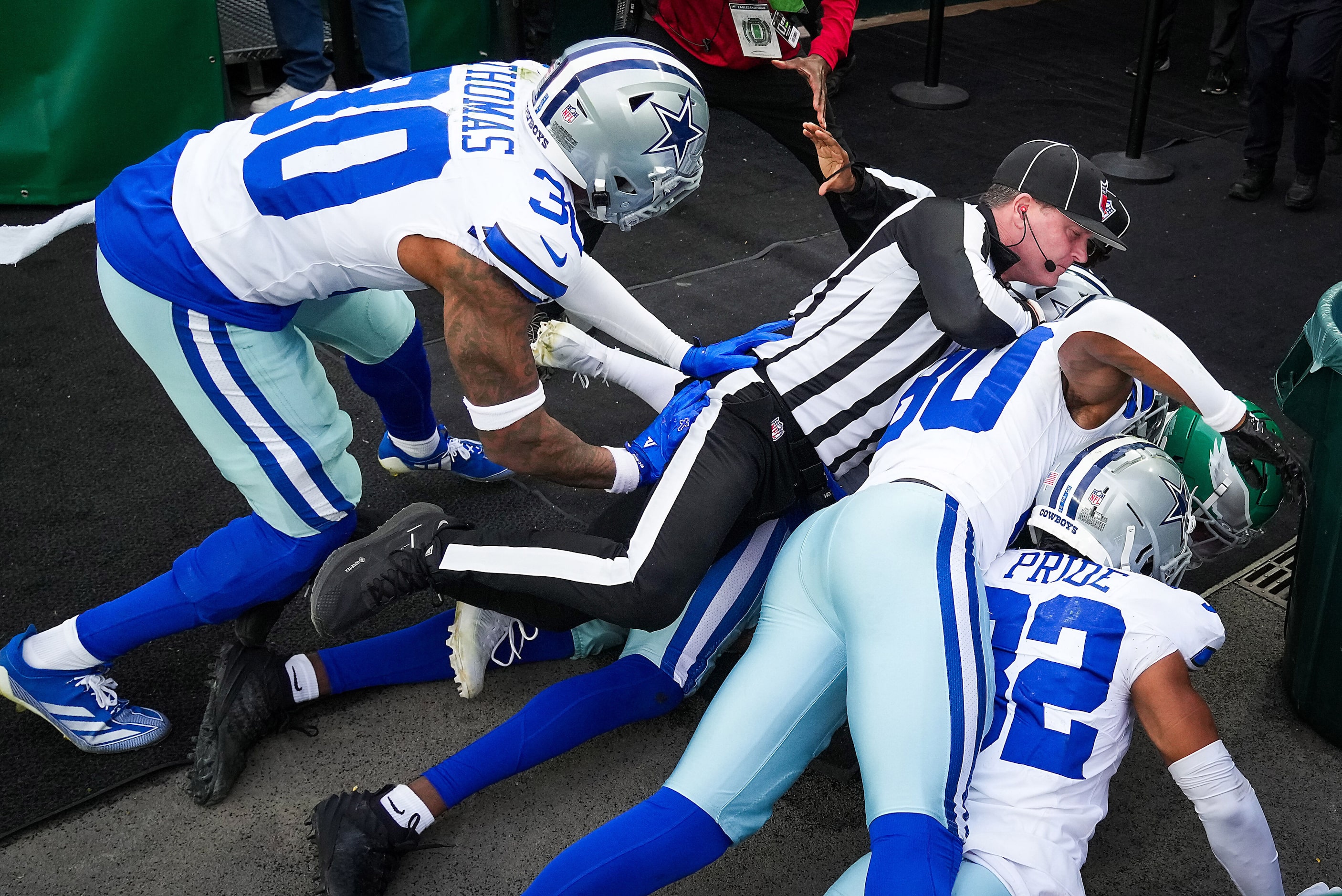 Side judge Chad Hill dives into a scrum that started with Philadelphia Eagles safety Sydney...