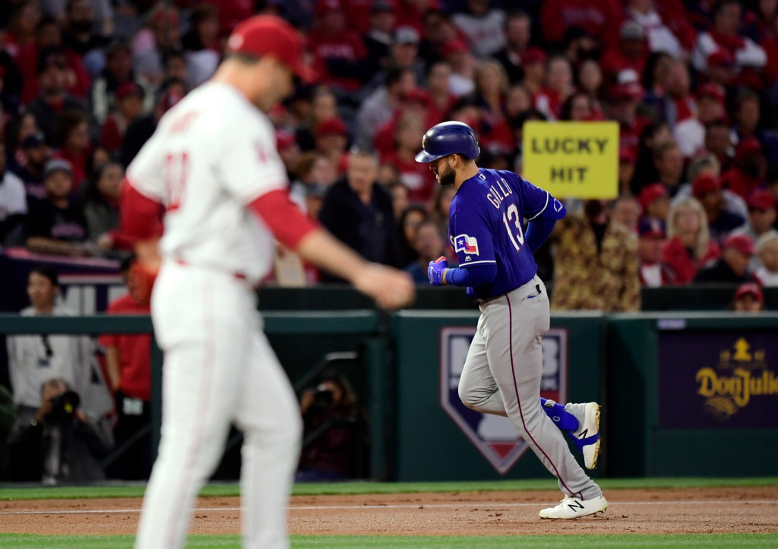 Texas Rangers' Joey Gallo, rear, rounds third after hitting a three-run home run off Los...