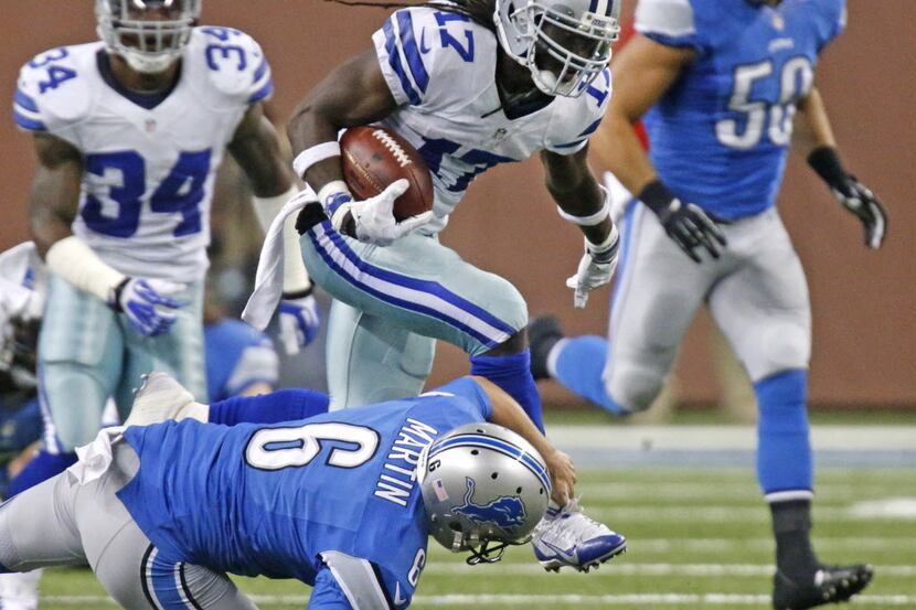 Dallas Cowboys kick returner Dwayne Harris (17) steps over Detroit Lions punter Sam Martin...