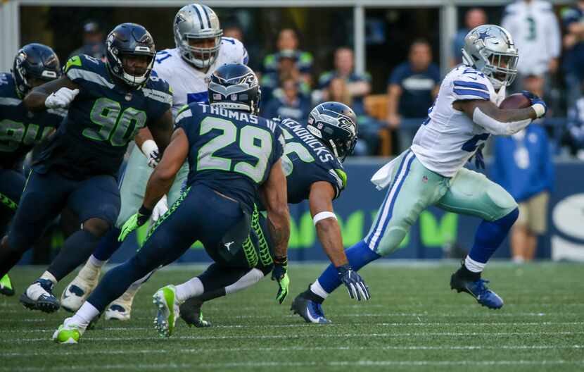 Dallas Cowboys running back Ezekiel Elliott (21) carries the ball past the Seattle Seahawks...