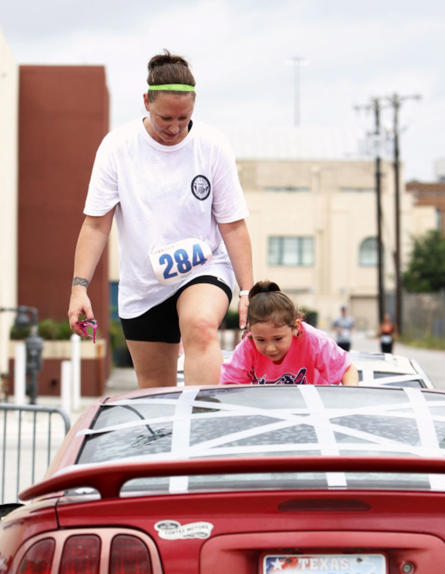 Alya Alvarado, 6, and her mother Shelly Gillaspie climb over junk cars during the Second...