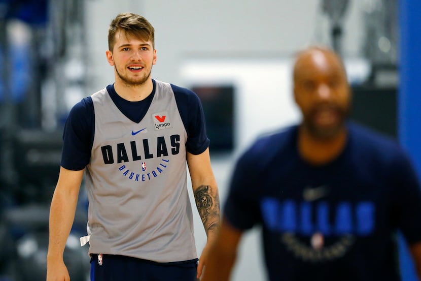 Dallas Mavericks Luka Doncic (77) watches as assistant coach Jamahl Mosley takes a shot from...