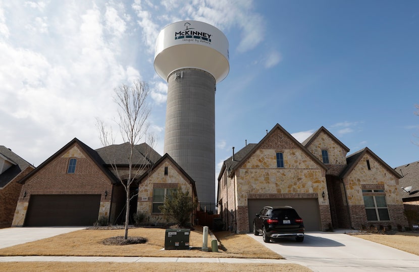 A McKinney water tower looms behind new homes on Leadville Way in fast-growing McKinney. The...