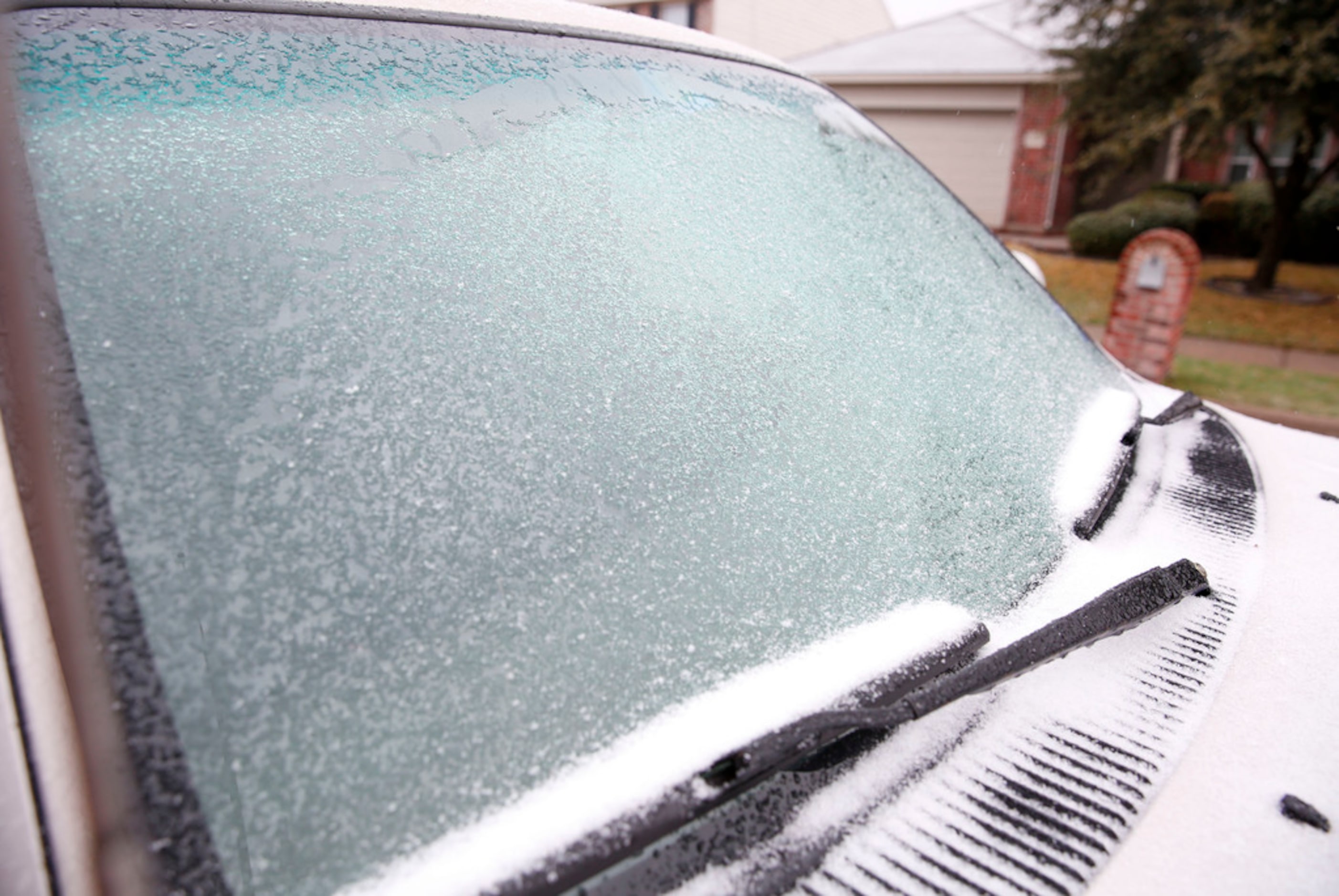 A wintry mix of ice and snow starts to stick to the ground in McKinney, Texas Saturday...