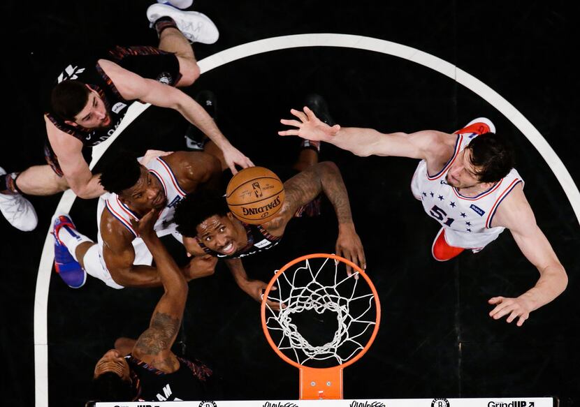 Philadelphia 76ers' Boban Marjanovic, right, shoots over Brooklyn Nets' Ed Davis, center,...