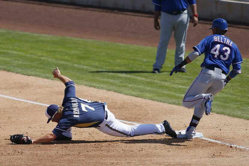 Milwaukee Brewers' Mark Reynolds (7) stretches for the ball but Texas Rangers' Engel Beltre...