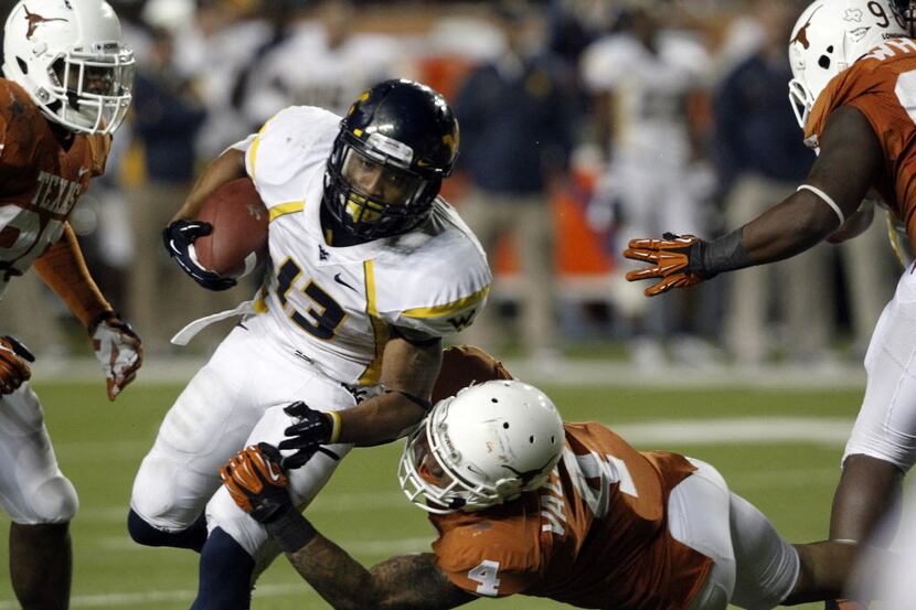 Texas Longhorns safety Kenny Vaccaro (4) tries to tackle West Virginia Mountaineers running...
