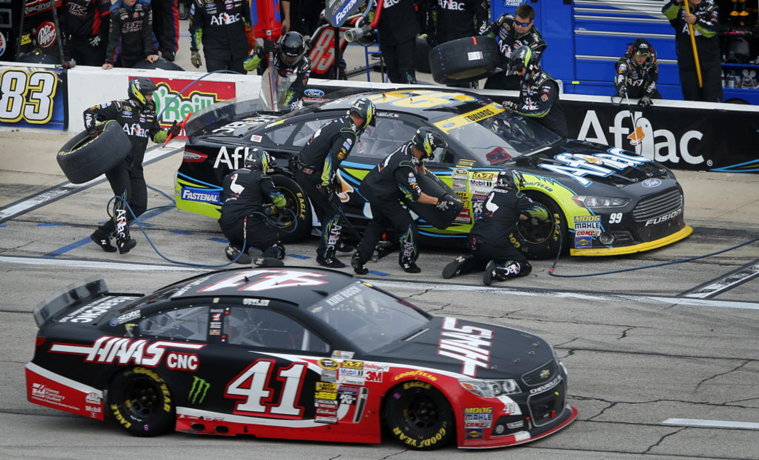 Sprint Cup Series driver Carl Edwards (99) receives a four-tire change during a pit stop in...