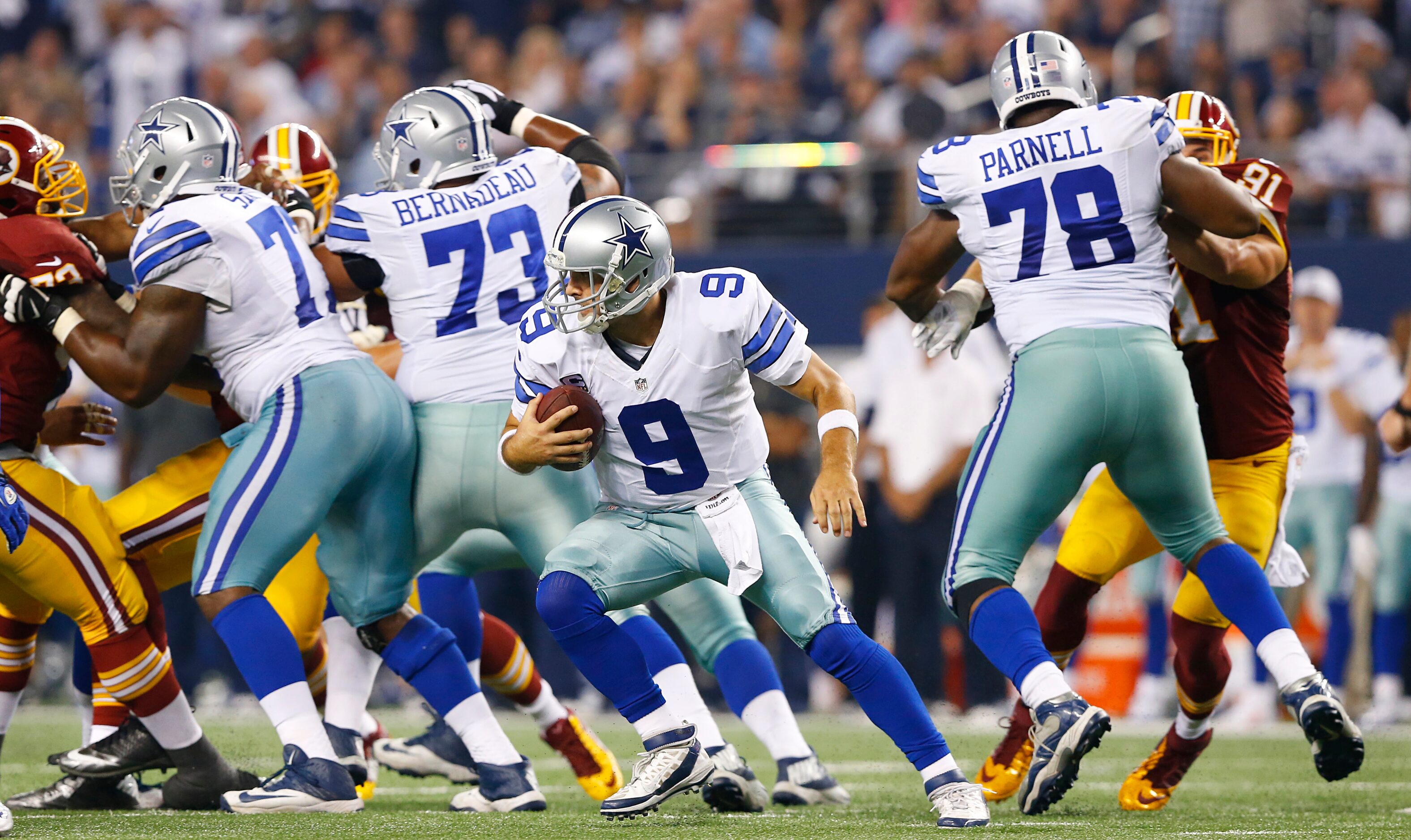 Dallas Cowboys quarterback Tony Romo (9) spins away from the Washington Redskins defense...