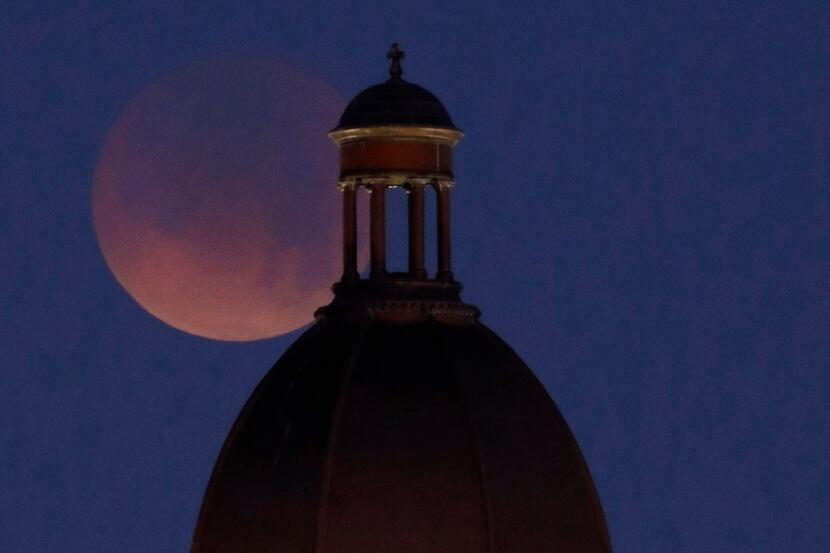 The Super Blue Blood Moon begins to set over the old Tarrant County Courthouse in downtown...